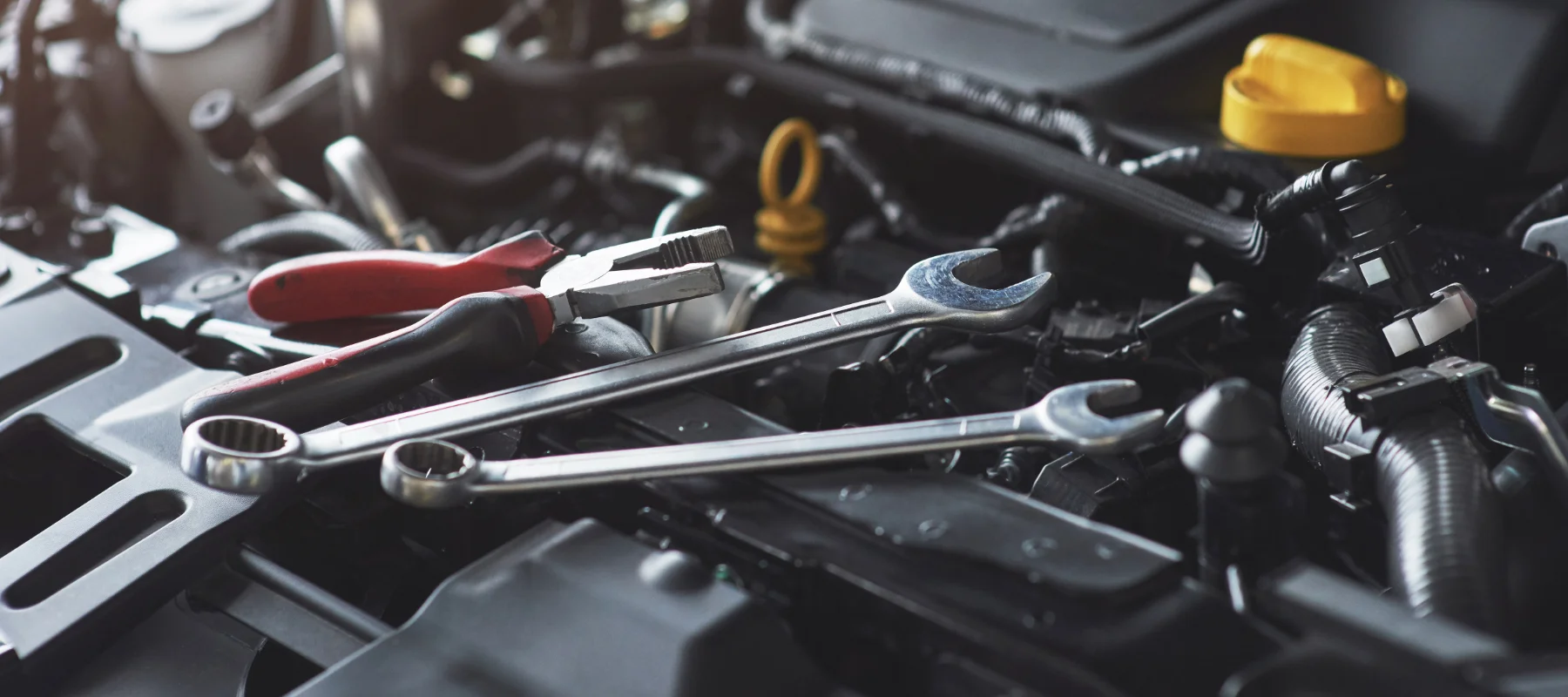 Closeup of an Uncle Al's mechanic's tools laid across a vehicles engine.