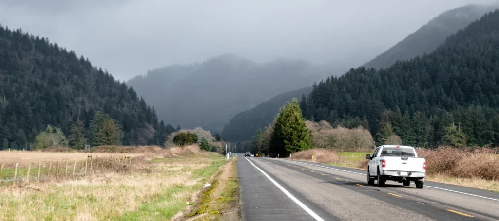 Closeup from behind an Uncle Al repaired vehicle as it drives across the outdoors of Gladstone Oregon.