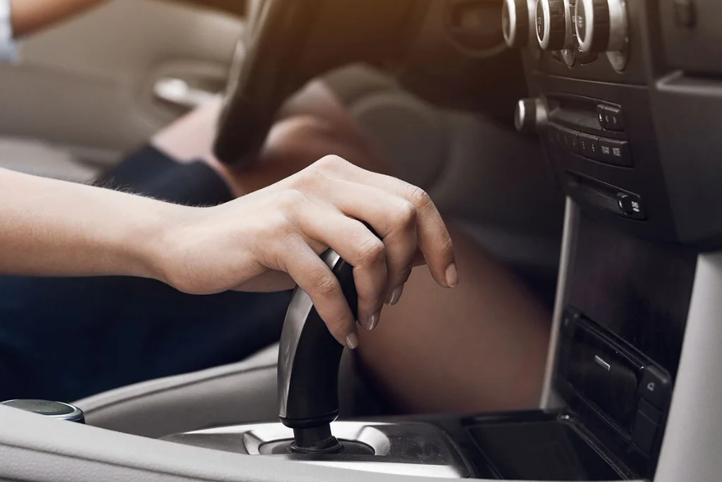 Closeup of a vehicle transmission being clutched by the automotive's driver.