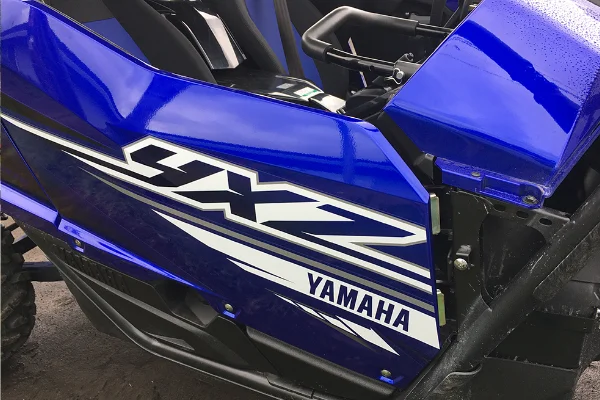 Closeup of the Yamaha logo on a blue YXZ four wheeler.