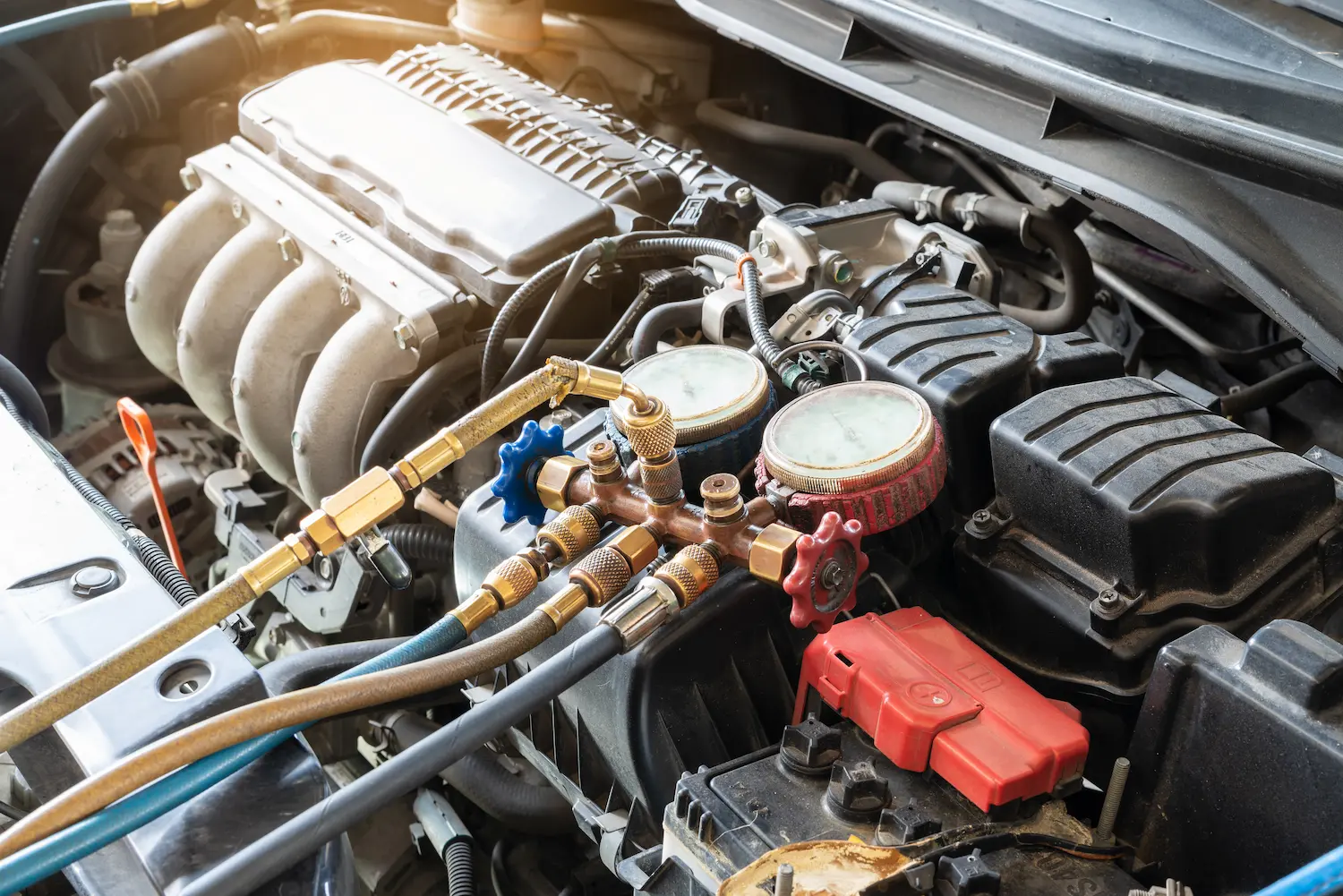 a car engine air conditioner being tested with a manifold gauge